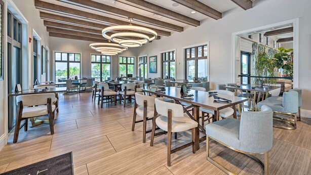 Une salle à manger spacieuse avec de hauts plafonds, un éclairage moderne et de grandes fenêtres.