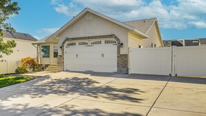 A single-story house with a garage, a covered porch, and a well-maintained lawn. - Family Home w/ Fenced Yard Between Provo & Slc! (Herriman)