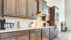 A modern kitchen with dark wood cabinets, a white tiled backsplash, and stainless steel appliances. - Pool Access: Family Gem w/ Views in St Cloud! (St. Cloud)