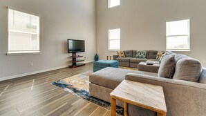 A spacious living room with a large sectional sofa, a flat-screen TV, and a wooden coffee table. - Pool Access: Family Gem w/ Views in St Cloud! (St. Cloud)