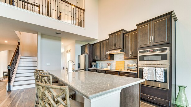 A spacious kitchen with dark wood cabinets, a large island, and stainless steel appliances. - Pool Access: Family Gem w/ Views in St Cloud! (St. Cloud)