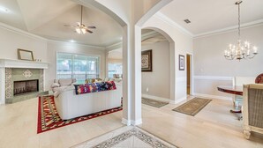 A spacious living room with a fireplace, a ceiling fan, and a chandelier. - 8 Mi to Lake Palestine: Peaceful Family Retreat (Flint)