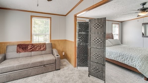 A bedroom with a bed, a sofa, a ceiling fan, and a window. - 1 Mi to Geneva SP: Family Home w/ Game Room & Yard (Geneva)