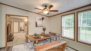 A dining area with a wooden table, benches, and a ceiling fan. There are windows with blinds, a rug, and a door leading to another room. - 1 Mi to Geneva SP: Family Home w/ Game Room & Yard (Geneva)