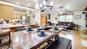 A spacious kitchen with wooden cabinets, a dining table set for six, and a chandelier. - Blue Ridge Mtns Escape: Great for Groups! (Newland)