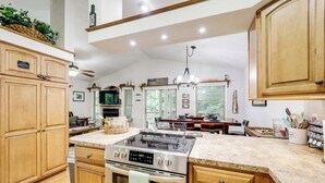 A spacious kitchen with wooden cabinets, a stainless steel stove, and a granite countertop. - Blue Ridge Mtns Escape: Great for Groups! (Newland)
