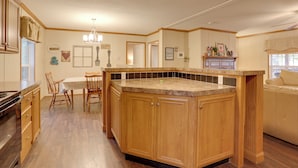 Una cucina con mobili in legno, un piano di lavoro in granito e un'area pranzo con tavolo e sedie.