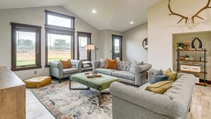 A spacious living room with a high ceiling, large windows, and a modern fireplace. - Pinedale Getaway Near Hiking, Skiing & Lakes! (Pinedale)