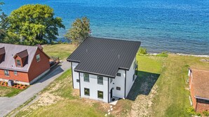 Moderni, kaksikerroksinen talo, jossa on tasakatto. Se sijaitsee vehreällä alueella, ja sen ikkunoista avautuu näkymä suurelle vesistölle.