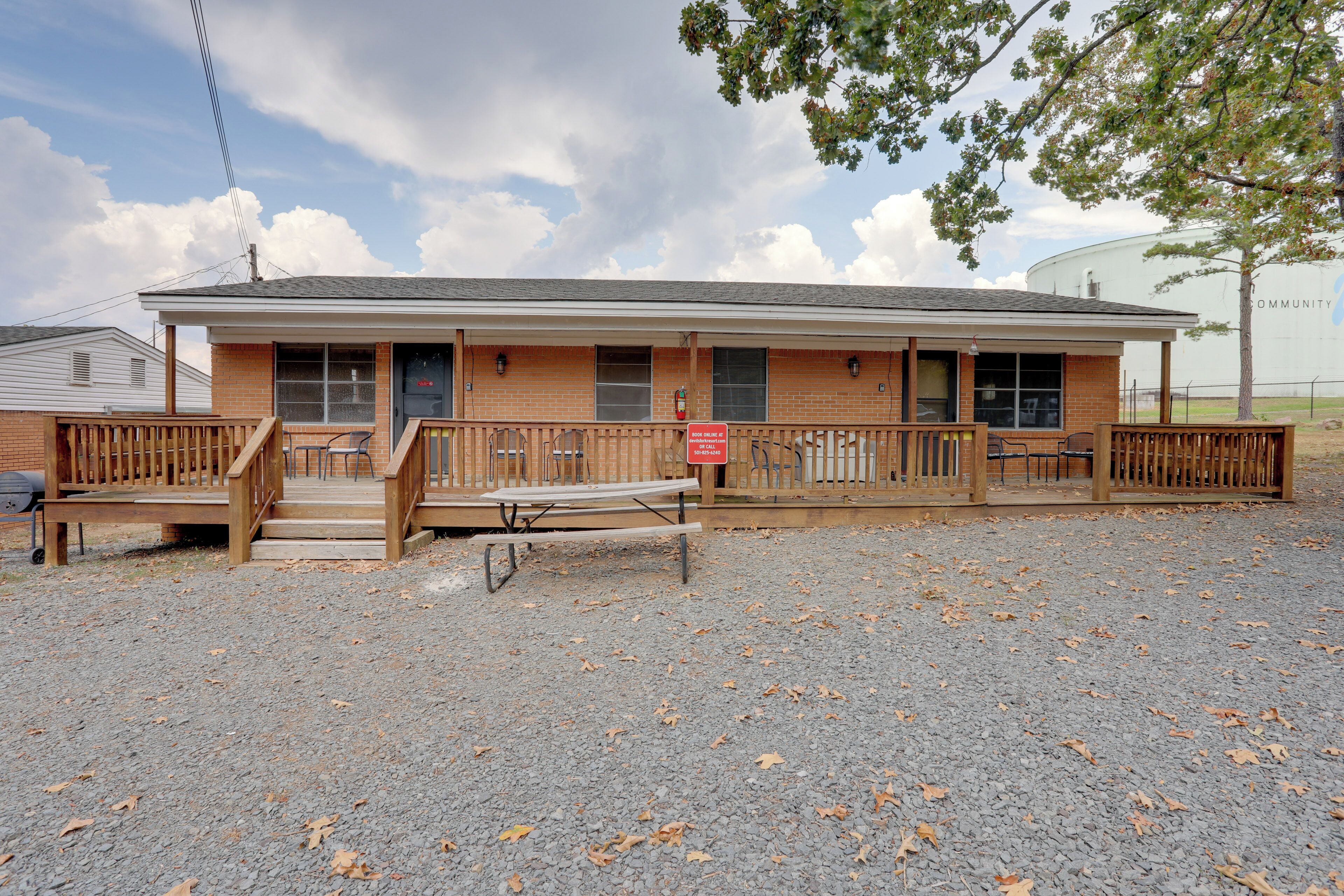 A single-story building with a covered porch, a fire hydrant, and a gravel driveway.