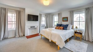 A bedroom with a bed, bedside table, lamp, and a flat-screen TV mounted on the wall. - Waterbury Studio 12 Mi to Bolton Valley Ski Resort (Waterbury)