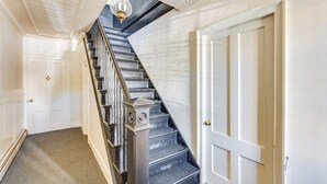 Eine Treppe mit Handlauf, einer Lampe darüber und einer Tür am unteren Ende.