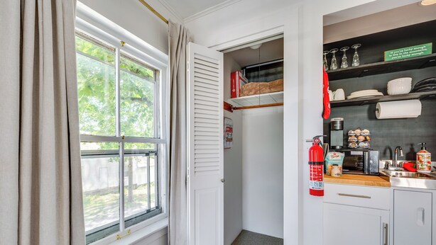 A compact kitchen with a window, a fire extinguisher, and a microwave. - 15 Mi to Stowe Mountain Resort: Main Street Studio (Waterbury)