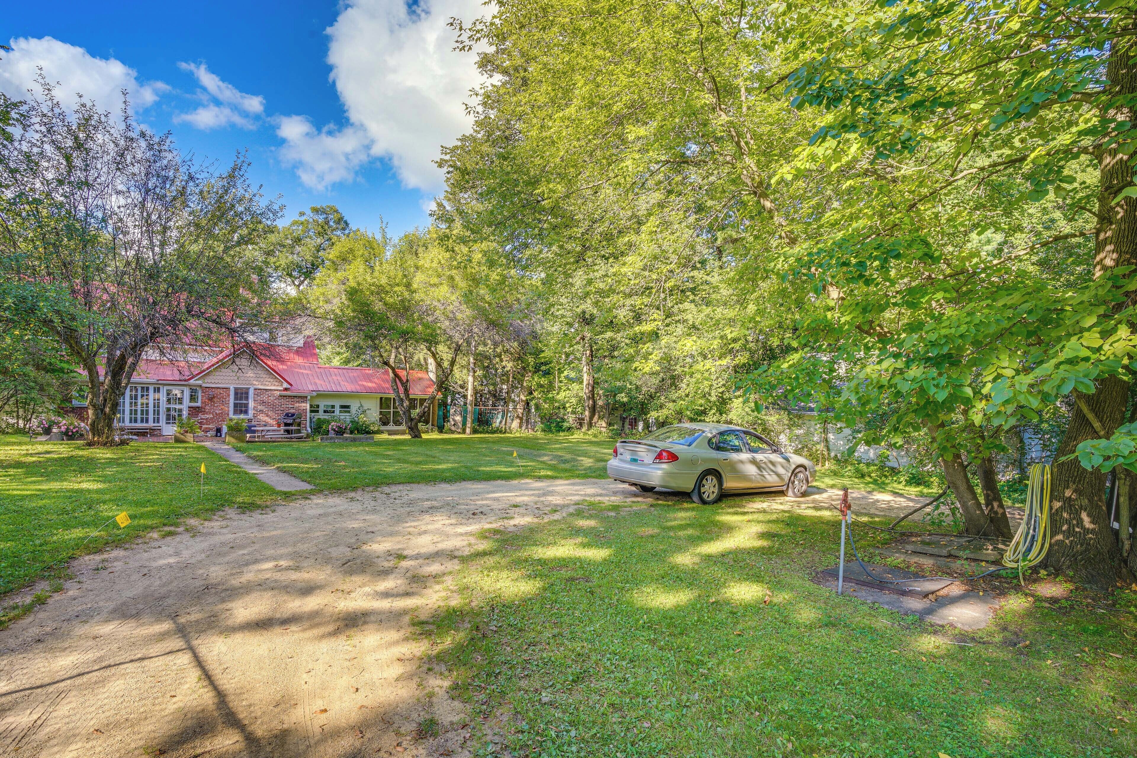 A residential property with a red-roofed house, a driveway, and a parked car.