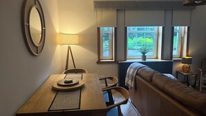A dining area with a wooden table, chairs, a bench, and a large mirror. - Modern, Stylish Flat on Baker Street — 5 mins walk to Stirling Castle (Stirling)