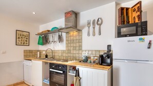 Una cucina compatta con forno a microonde, macchina del caffè e piccolo forno.