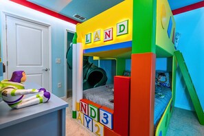 A child's play area with a bunk bed, colorful blocks spelling 'LAND,' and a toy Buzz Lightyear on a table. - Upstay Family Fun 5BR Retreat w Pool & Games Room (Clermont)