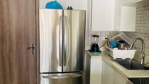 A compact kitchen with a stainless steel refrigerator, a sink, and a countertop with a blender. - 1 Bedroom Mountain Retreat New Kingston (Kingston)