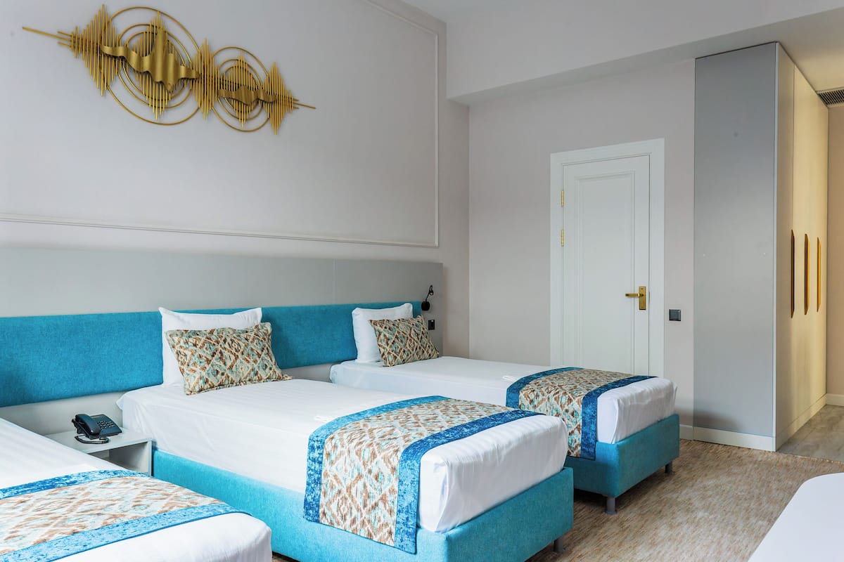 Deluxe Triple Room, Garden View | In-room safe, desk, laptop workspace, blackout drapes
