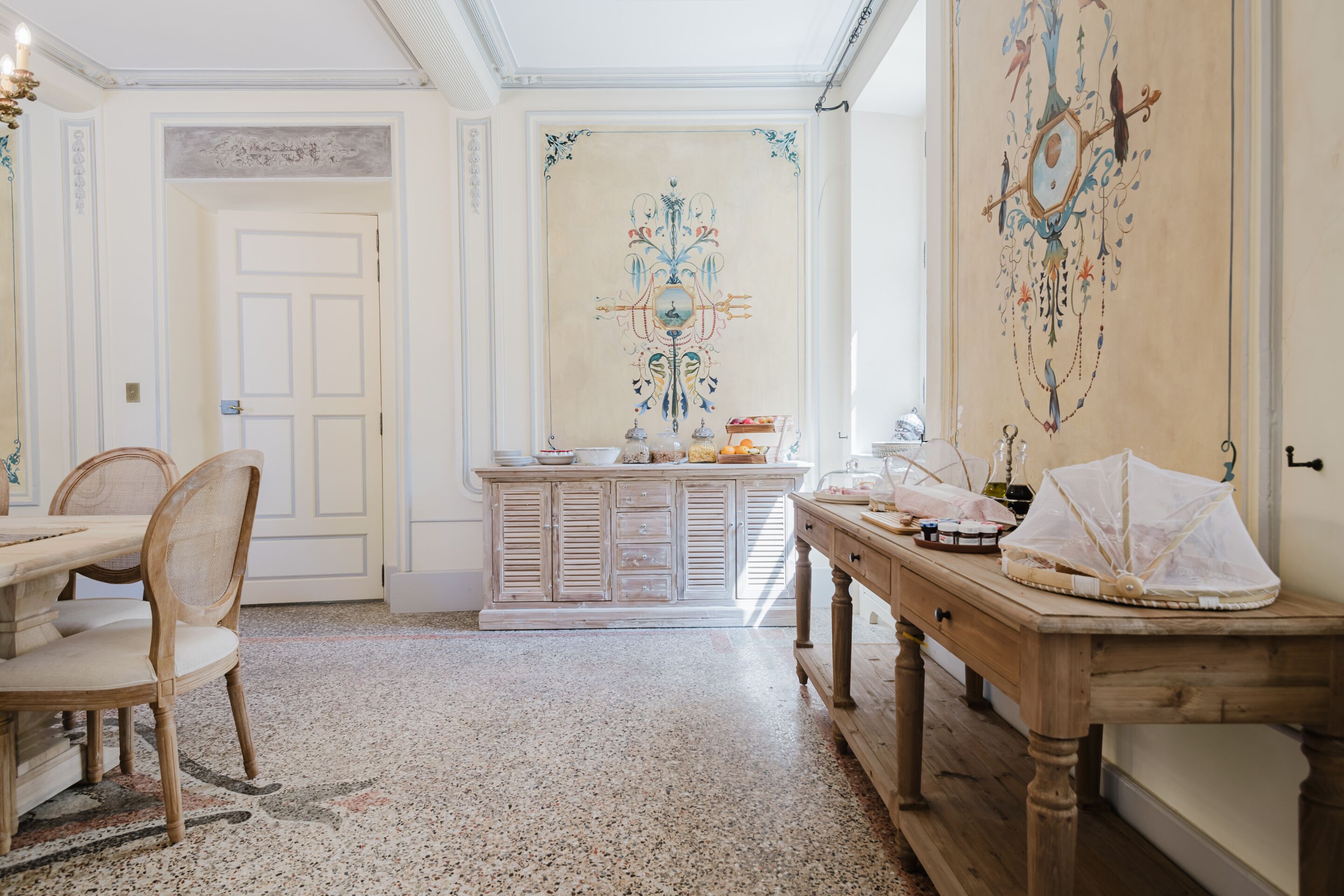 Une pièce comprenant une table à manger, des chaises, un buffet et un mur décoratif.