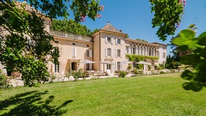 A large, historic building with multiple windows and a well-maintained lawn. - Château Saint Perret (Avignon)