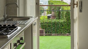 A kitchen with a view of a green lawn and mountains. - Complete vacation apartment between lake and mountains (Caslino D'erba)