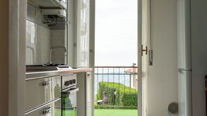 Una cocina con vista a un balcón y al paisaje urbano.