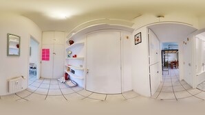 A corridor with white walls, a tiled floor, and a door leading to a bathroom. - Complete vacation apartment between lake and mountains (Caslino D'erba)