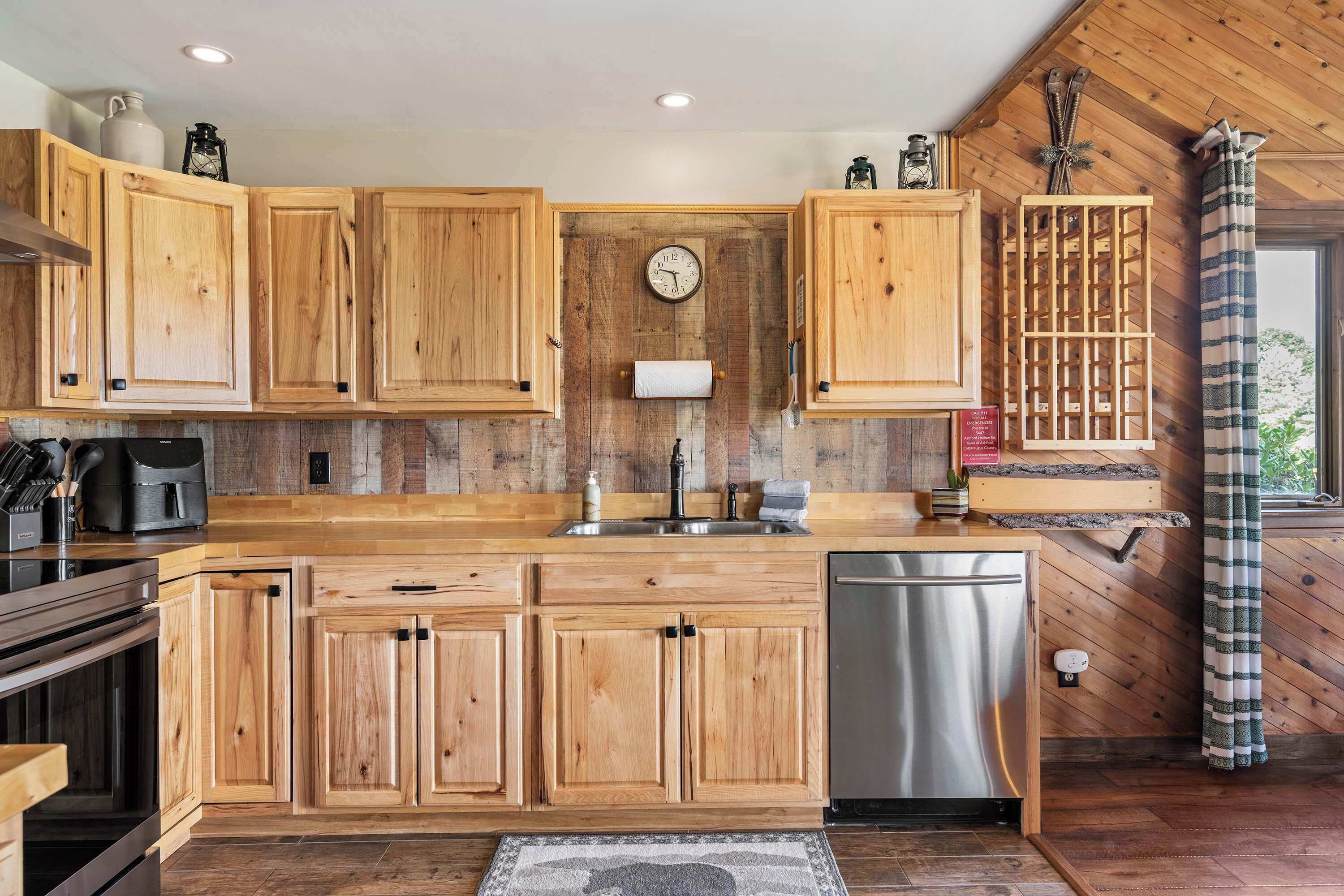 Una cocina con armarios de madera, lavavajillas de acero inoxidable y encimera de madera.