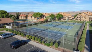 A tennis court complex with multiple courts, surrounded by residential buildings and a parking area. - Cozy Condo - Desert Mesa View! (St. George)
