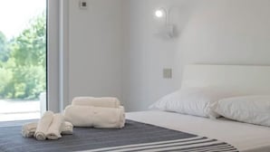 A hotel room with a bed, a window, and a wall-mounted light fixture. - Armonia Suites - Acqua- new apartment with garden and pool in Verona (Verona)