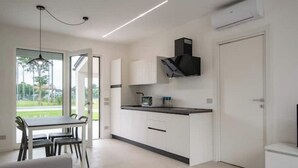 A modern kitchen with white cabinets, a black countertop, and a built-in microwave. - Armonia Suites - Acqua- new apartment with garden and pool in Verona (Verona)
