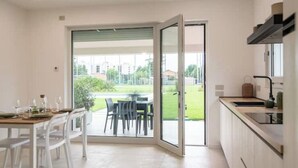 A modern kitchen with a sliding glass door leading to an outdoor dining area. - Armonia Suites -Earth and Water new apartments with garden and pool in Verona (Verona)