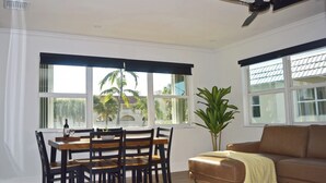 Un comedor con una mesa y sillas, una planta en maceta y un sofá.