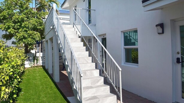 Un edificio moderno y blanco con una escalera que lleva a la entrada.