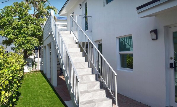 Un edificio moderno y blanco con una escalera que lleva a la entrada.