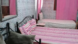 Ein Schlafzimmer mit Bett, einem Sessel und einem kleinen Tisch.