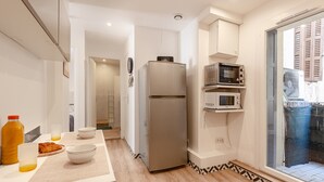 Cozinha moderna com geladeira, micro-ondas e espaço para café da manhã no balcão.
