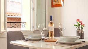 Uma mesa de jantar com pratos brancos, copos de vinho e uma garrafa de vinho Villabucco.