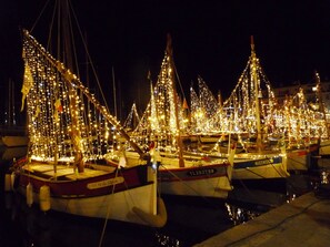 Eine Marina bei Nacht mit vertäuten Booten, beleuchtet durch Lichterketten.