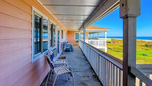 A covered porch with a view of the ocean, wooden walls, and several chairs. - Beachgate Condo Suites And Hotel 234+235+236 3 Bedroom Condo (Port Aransas)