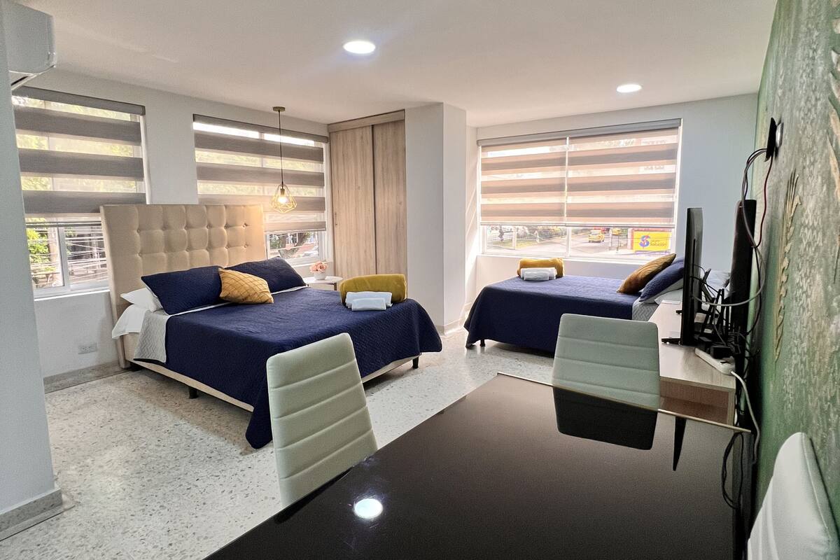 Une chambre d’hôtel avec deux lits, un bureau et une télévision.
