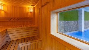 A wooden sauna with benches and a window overlooking a pool area. - Penthouse Morning Star by Fidalsa (Torrevieja)