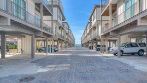 A modern apartment building with a central courtyard, multiple balconies, and a clear blue sky. - Little Lagoon Cottage for 8 - Free Activities (Gulf Shores)