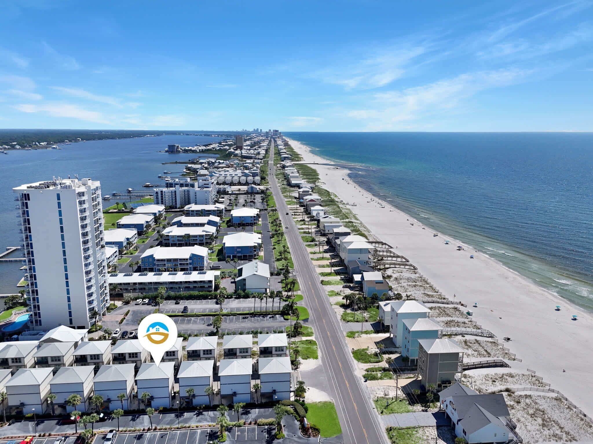 A coastal hotel with multiple buildings, a beach, and a marina.