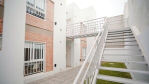 A multi-level building with a staircase, a door labeled '2', and a small grassy area. - Temporary South with garden for 4 people with 3 beds, in General Roca, IUPA area. (General roca)