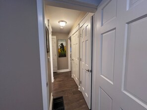 A hallway with white doors, a wooden floor, and a ceiling light. - Smuggler Mine — Pet-Friendly Condo in Telluride (Telluride)