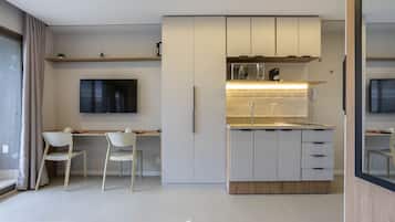 Una cocina moderna con armarios blancos, un microondas integrado y una encimera.