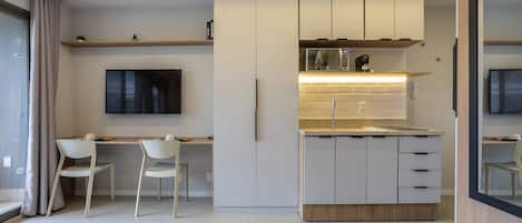 A modern kitchen with white cabinetry, a built-in microwave, and a countertop.