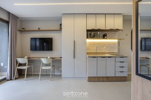 Una cocina moderna con armarios blancos, un microondas integrado y una encimera.